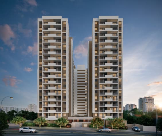 Fachada frontal dos edifícios residenciais ao entardecer com tráfego na rua.