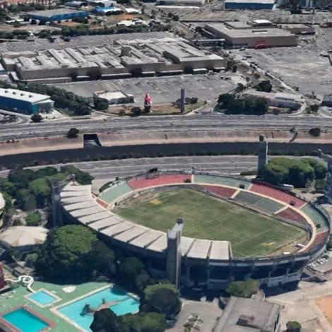 Vista aérea da região com estádio de futebol e vias urbanas.