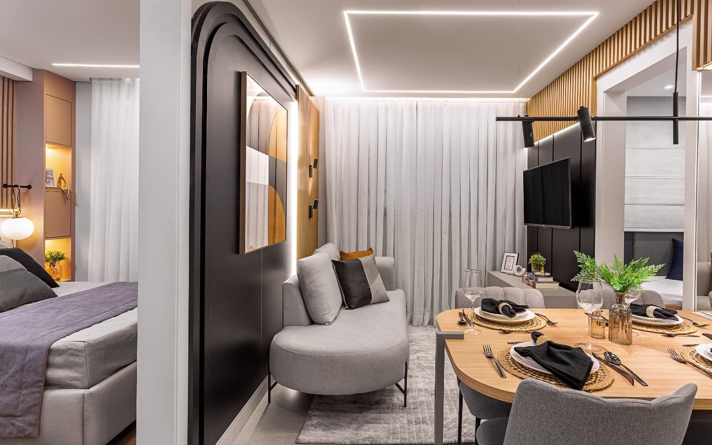 Sala de estar e jantar integradas com sofá cinza e mesa de jantar