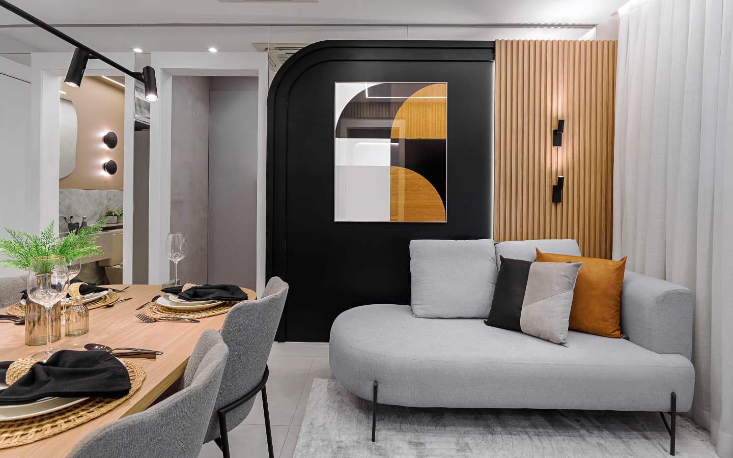 Sala de estar com sofá cinza, almofadas coloridas e painel ripado