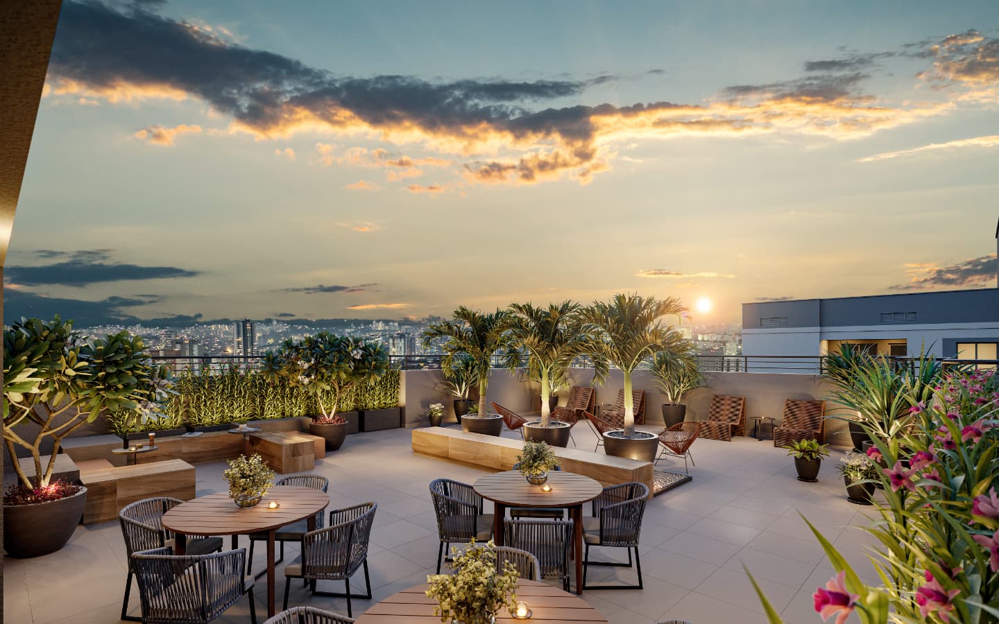 Terraço descoberto com mesas, vasos de plantas e vista panorâmica ao pôr do sol
