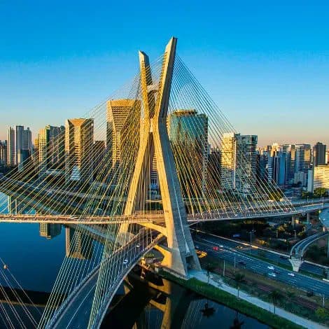 Vista aérea da Ponte Estaiada sobre o rio com prédios urbanos ao fundo.