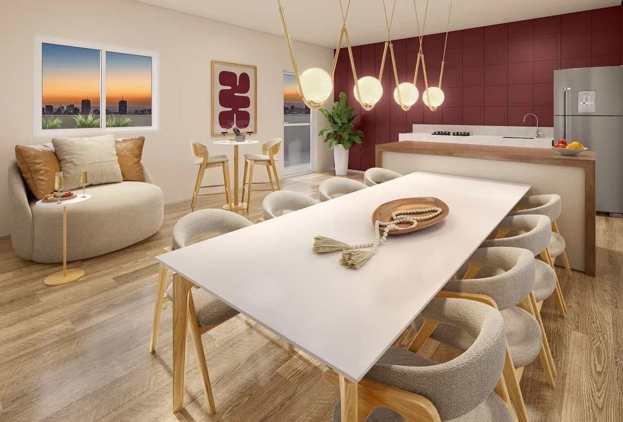 Sala de jantar integrada com mesa grande, cadeiras estofadas e cozinha ao fundo.