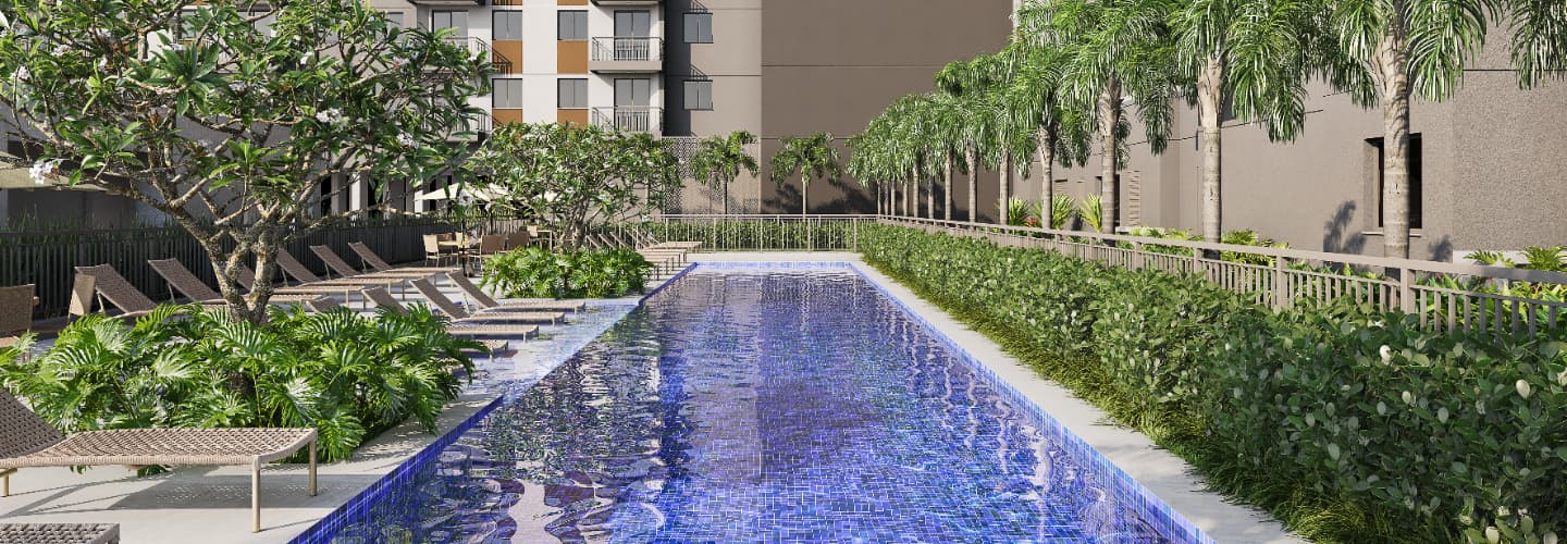 Piscina externa cercada por espreguiçadeiras, árvores e paisagismo.