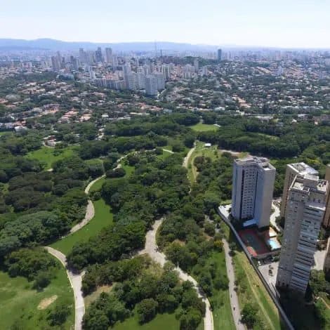 Vista aerea de regiao arborizada e edificacoes urbanas.