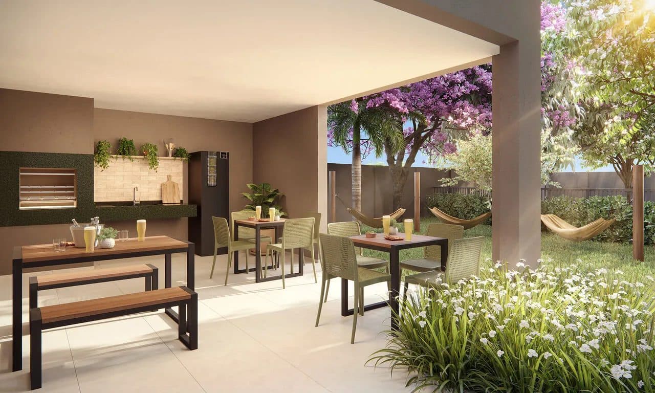 Área gourmet externa coberta com churrasqueira, mesas e jardim com redes