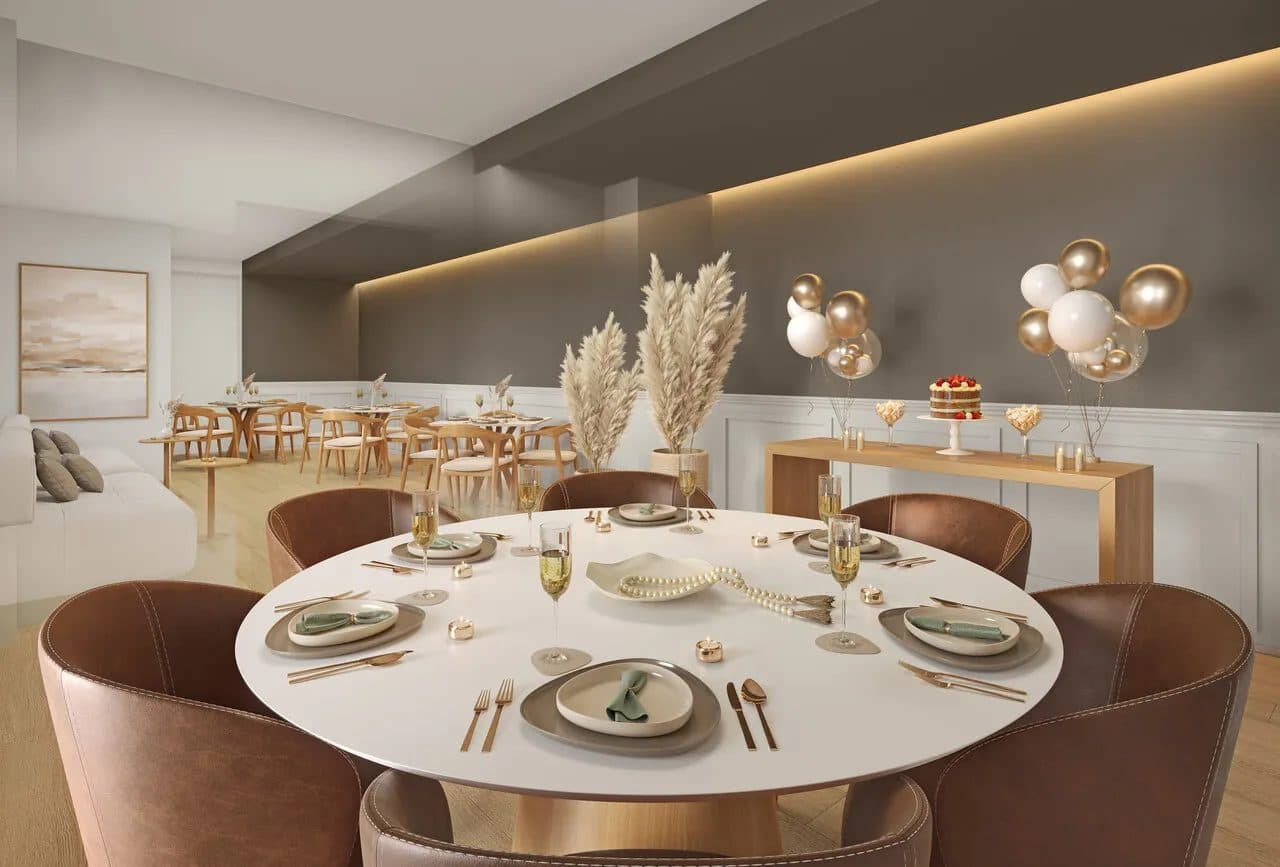 Espaço interno com mesas redondas decoradas para recepção e balcão de doces