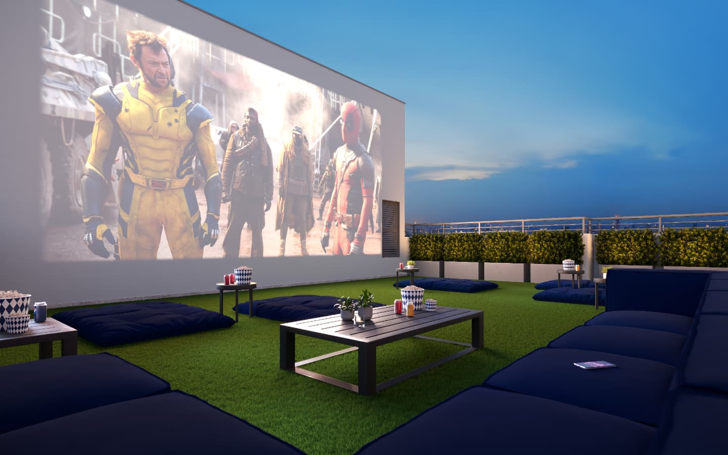 Área de cinema ao ar livre com gramado artificial, pufes e telão na parede