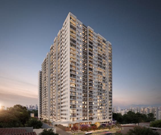 Vista externa de edifício residencial com janelas e varandas ao entardecer.