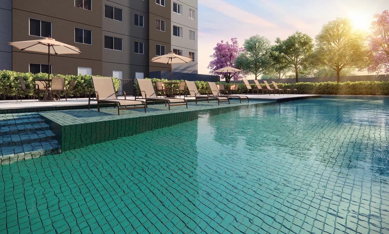 Piscina com espreguiçadeiras e guarda-sóis na área externa do condomínio.